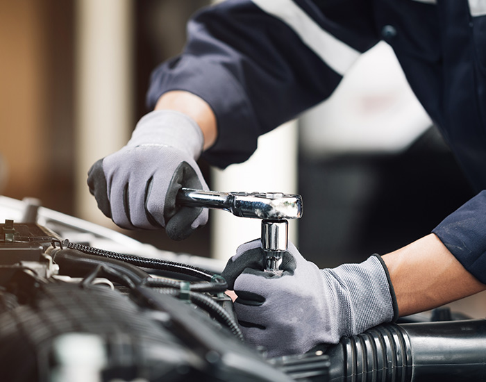 Mechanic works on the engine of the car in the garage