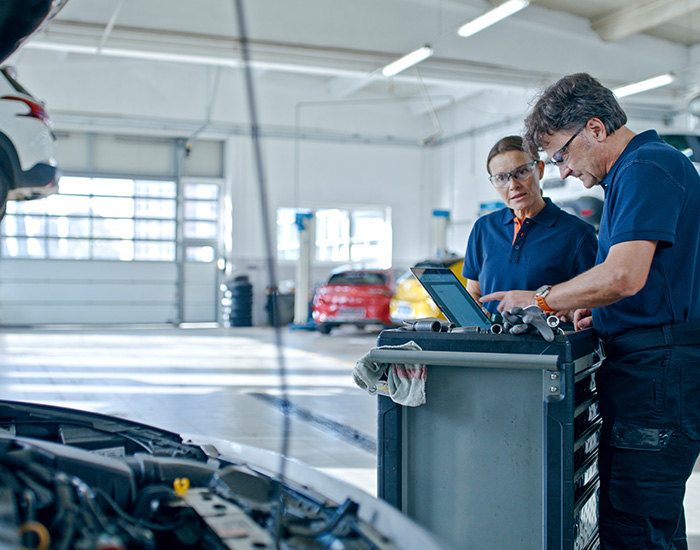 Manager And Mechanic Conducting A Thorough Inspection Of A Car Engine